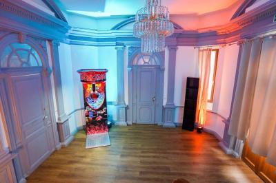 Cuisine moderne avec îlot central noir, chaises hautes, meubles rouges, électroménagers intégrés et carrelage blanc.