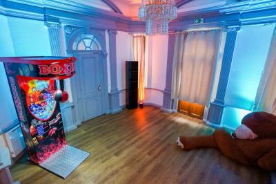 Cuisine moderne avec îlot central noir, chaises hautes, meubles rouges, électroménagers intégrés et carrelage blanc.