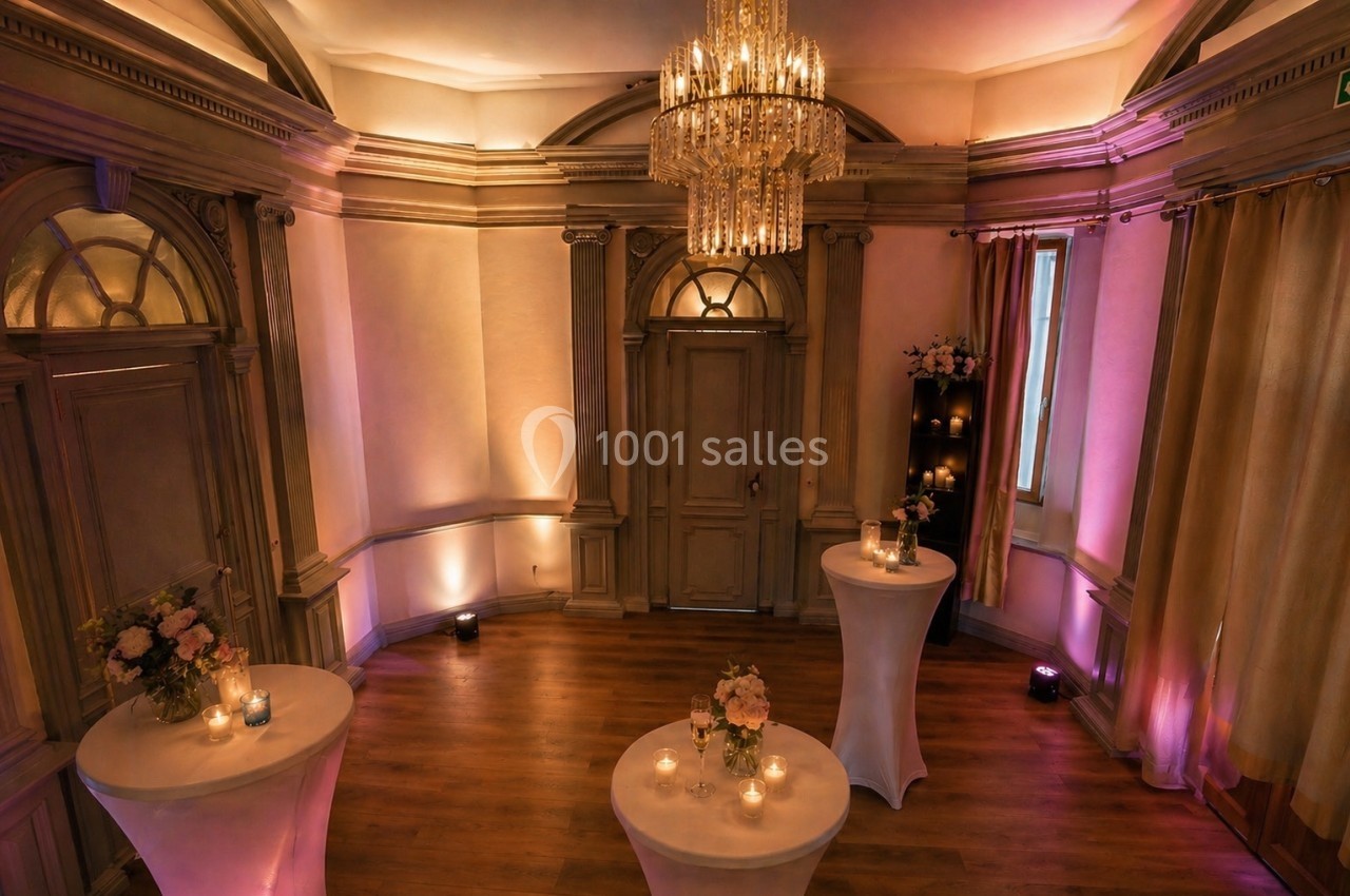 Location salle Nanterre (Hauts-de-Seine) - Manoir Loft 92 #4 Salle élégante avec parquet, tables hautes décorées de fleurs et bougies, éclairage tamisé et lustre central.