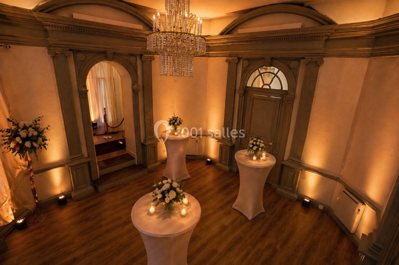 Location salle Nanterre (Hauts-de-Seine) - Manoir Loft 92 #2 Salle élégante avec parquet, tables hautes décorées de fleurs et bougies, éclairage chaleureux et lustre central.