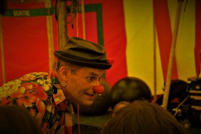 Un spectacle avec deux artistes sur scène dans une salle en pierre, face à un public levant les bras.