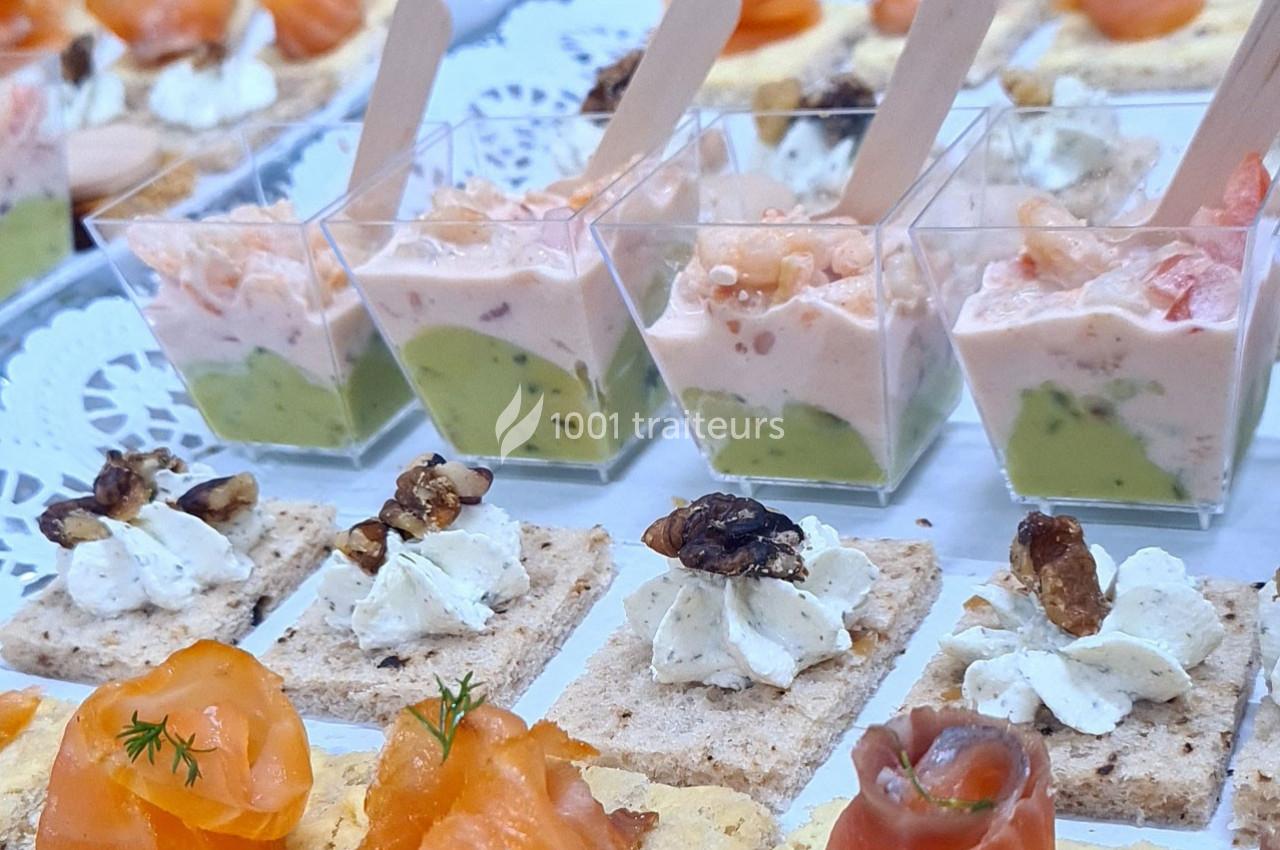 Plateau de canapés variés avec verrines de crevettes à l'avocat, toasts au saumon fumé et fromage frais aux noix.