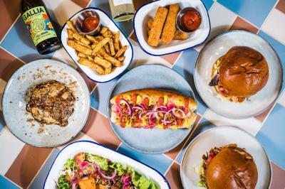 Plateau de mini-burgers au pain brioché, garnis de viande et de légumes colorés.