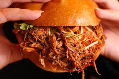 Plateau de mini-burgers au pain brioché, garnis de viande et de légumes colorés.