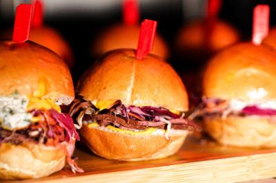 Plateau de mini-burgers au pain brioché, garnis de viande et de légumes colorés.
