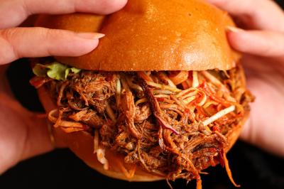 Plateau de mini-burgers au pain brioché, garnis de viande et de légumes colorés.