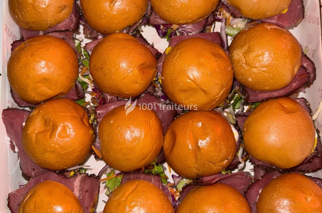 Plateau de mini-burgers au pain brioché, garnis de viande et de légumes colorés.