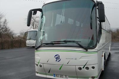 Vue intérieure d'un autocar avec des sièges rembourrés et un toit vitré laissant passer la lumière naturelle.