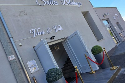 Miniature Location salle Charleroi (Hainaut) - Salles Belidanza #3 Salle de réception décorée avec des tables rondes, nappes beige, chaises ornées de nœuds et compositions florales.