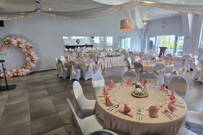 Miniature Location salle Charleroi (Hainaut) - Salles Belidanza #8 Salle de réception décorée avec des tables rondes, nappes beige, chaises ornées de nœuds et compositions florales.