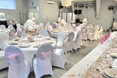 Miniature Location salle Charleroi (Hainaut) - Salles Belidanza #7 Salle de réception décorée avec des tables rondes, nappes beige, chaises ornées de nœuds et compositions florales.