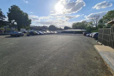 Miniature parking Salle de réception décorée avec des tables rondes, nappes beige, chaises ornées de nœuds et compositions florales.