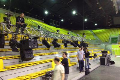 Salle de réception avec tables dressées et invités, éclairée par des lumières colorées et des motifs projetés au sol.