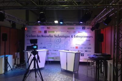 Salle de réception avec tables dressées et invités, éclairée par des lumières colorées et des motifs projetés au sol.