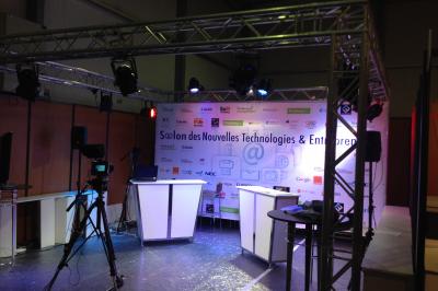 Salle de réception avec tables dressées et invités, éclairée par des lumières colorées et des motifs projetés au sol.