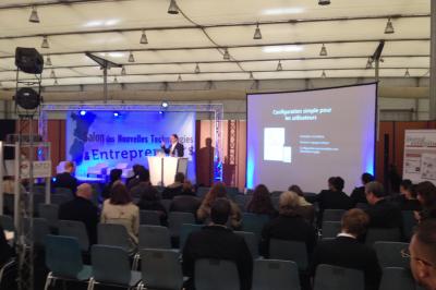 Salle de réception avec tables dressées et invités, éclairée par des lumières colorées et des motifs projetés au sol.