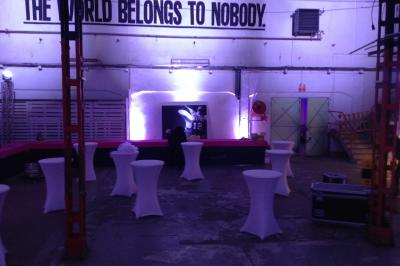 Salle de réception avec tables dressées et invités, éclairée par des lumières colorées et des motifs projetés au sol.