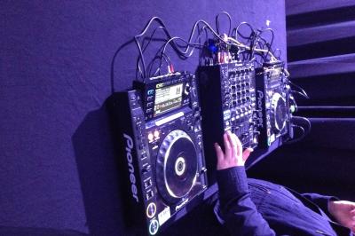 Salle de réception avec tables dressées et invités, éclairée par des lumières colorées et des motifs projetés au sol.