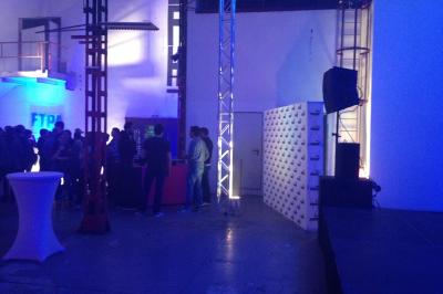 Salle de réception avec tables dressées et invités, éclairée par des lumières colorées et des motifs projetés au sol.