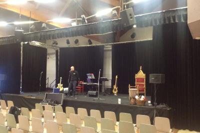 Salle de réception avec tables dressées et invités, éclairée par des lumières colorées et des motifs projetés au sol.