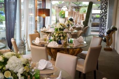 Miniature Location salle Moineville (Meurthe-et-Moselle) - Les Jardins de L'Hacienda #34 Salle de réception élégante avec tables rondes décorées de fleurs blanches et serviettes pliées, ambiance lumineuse.