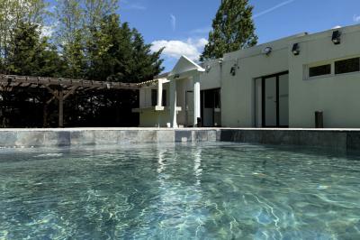 Miniature Location salle Roquevaire (Bouches-du-Rhône) - Nao Athéna #9 Table dressée avec vaisselle et fleurs bleues près d'une piscine entourée de dalles claires et de végétation.