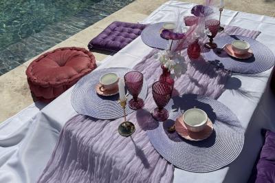 Miniature Location salle Roquevaire (Bouches-du-Rhône) - Nao Athéna #19 Table dressée avec vaisselle et fleurs bleues près d'une piscine entourée de dalles claires et de végétation.