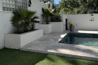 Miniature Location salle Roquevaire (Bouches-du-Rhône) - Nao Athéna #21 Table dressée avec vaisselle et fleurs bleues près d'une piscine entourée de dalles claires et de végétation.