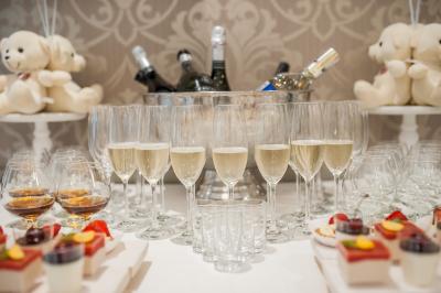 Miniature Traiteur Garancières (Yvelines) - Fb Traiteur #9 Verres de champagne alignés devant un seau à glace rempli de bouteilles, avec desserts et peluches en arrière-plan.