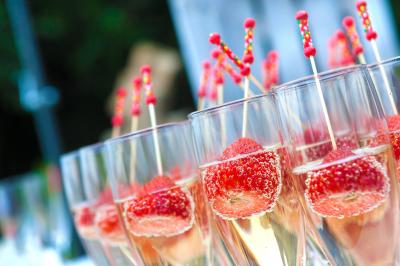 Miniature Traiteur Garancières (Yvelines) - Fb Traiteur #5 Verres de champagne alignés devant un seau à glace rempli de bouteilles, avec desserts et peluches en arrière-plan.