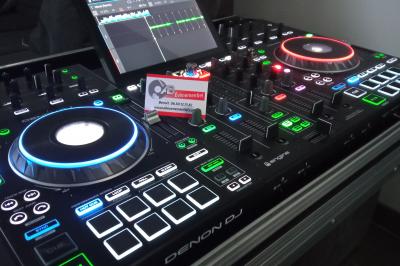 Miniature DJ Linselles (Nord) - AB Evènementiel #10 Mur en briques éclairé par des lumières rouges et vertes avec des enceintes noires sur pieds alignées.