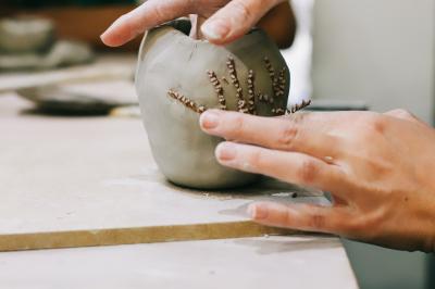 Personnes créant un collage avec des découpages de magazines, des bâtons de colle et une table en bois.
