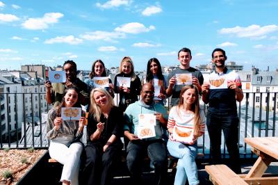Personnes créant un collage avec des découpages de magazines, des bâtons de colle et une table en bois.