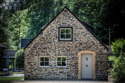 Miniature Location salle Habay (Luxembourg) - Château du Pont d'Oye #18 Façade d'une maison en pierre avec porte beige, fenêtres blanches et environnement boisé en arrière-plan.