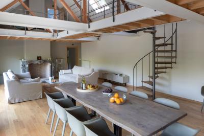 Deux colonnes en pierre encadrent un espace avec deux bureaux modernes, éclairés par des lampes murales.