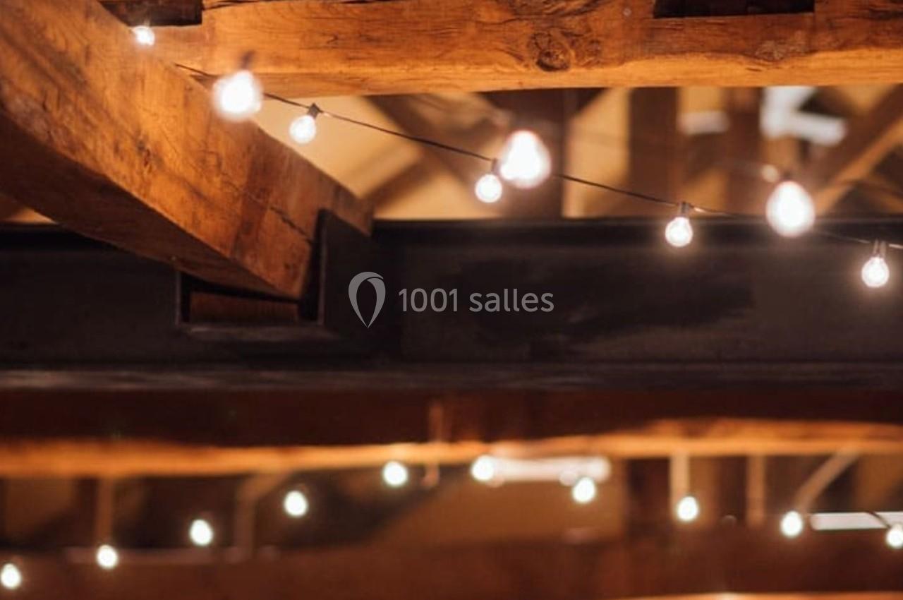 Plafond en bois avec des poutres apparentes, décoré de guirlandes lumineuses suspendues.