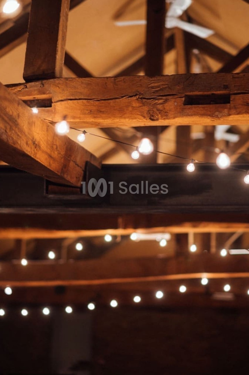 Plafond en bois avec des poutres apparentes, décoré de guirlandes lumineuses suspendues.