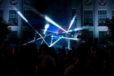 Un couple danse dans une salle éclairée par des lumières colorées et entourée de fumée.