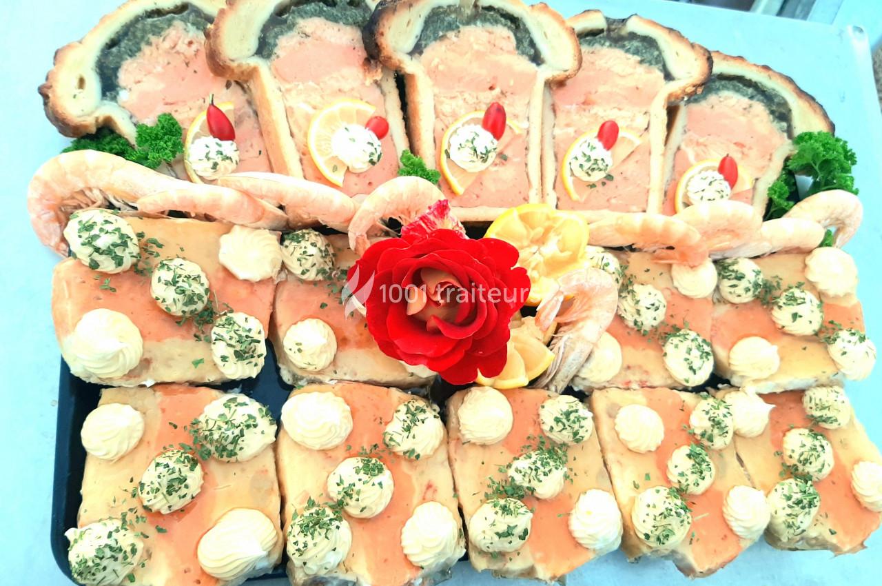 Plateau de bouchées apéritives avec pâté en croûte, crevettes, mousse et décorations de citron et persil.