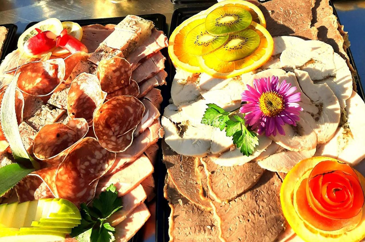 Plateaux de charcuterie et de viandes froides garnis de fruits, légumes et fleurs décoratives.