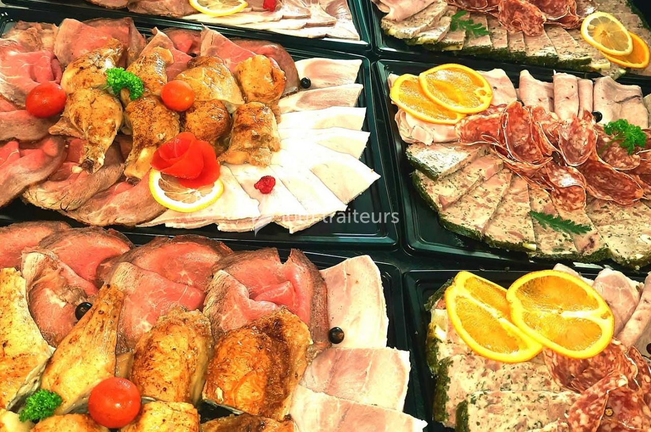 Plateaux de charcuterie variés avec viandes, pâtés, tranches de jambon, agrémentés de fruits et décorations.