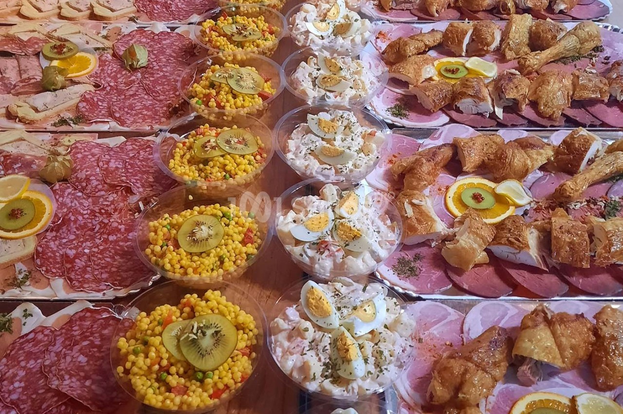 Plateau de charcuterie, salades composées et viennoiseries salées, présenté sur une table pour un buffet.