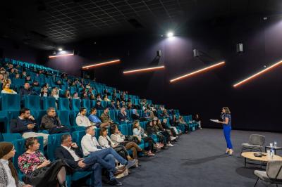 Vue aérienne d'une péninsule boisée entourée de mer, avec des montagnes enneigées à l'horizon.