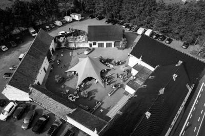 Miniature Location salle Leuze-en-Hainaut (Hainaut) - La Grenouillère #2 Terrasse en bois avec salon de jardin, sauna en forme de tonneau, jacuzzi et clôture en bois, entourée de verdure.