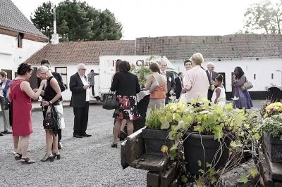 Miniature Location salle Leuze-en-Hainaut (Hainaut) - La Grenouillère #9 Terrasse en bois avec salon de jardin, sauna en forme de tonneau, jacuzzi et clôture en bois, entourée de verdure.