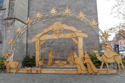 Vue nocturne d'un showroom automobile éclairé, avec une affiche promotionnelle d'un véhicule BMW X1 au premier plan.