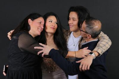 Femme portant une tenue rose satinée, posant devant un fond uni gris clair.