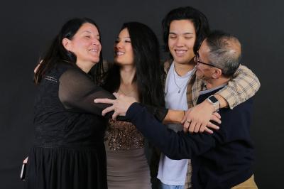 Femme portant une tenue rose satinée, posant devant un fond uni gris clair.