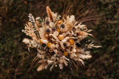 Un couple assis lors d'une cérémonie, l'homme ému essuie une larme tandis que la femme le regarde avec tendresse.