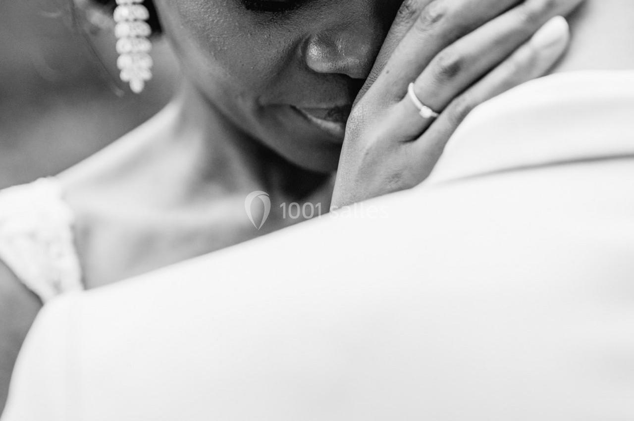 Femme émue posant sa main sur la tête d'un homme, capturée en noir et blanc dans un moment intime.